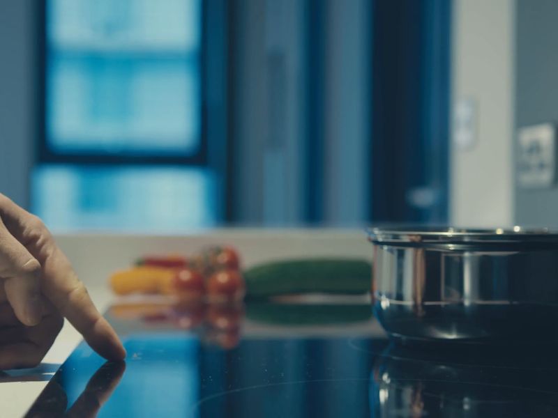 osoba koristi indukcionu ploču