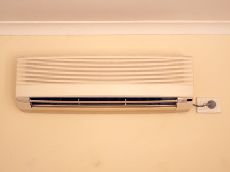 klima uređaj na žutom zidu