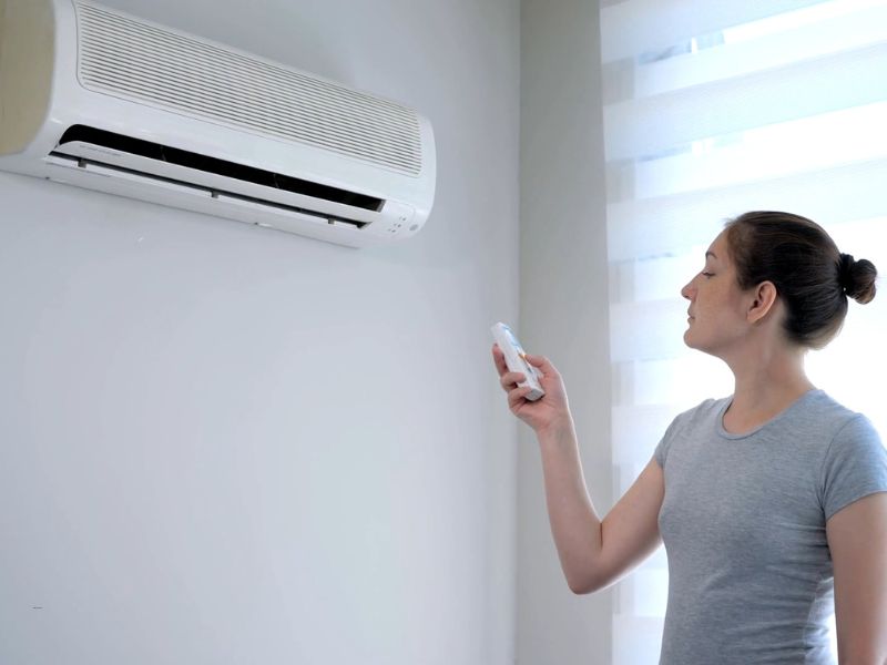 devojka uključuje klimu